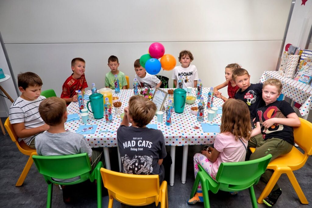 Dzieci przy stole urodzinowym w salce Parku Fantazja w Andrychowie