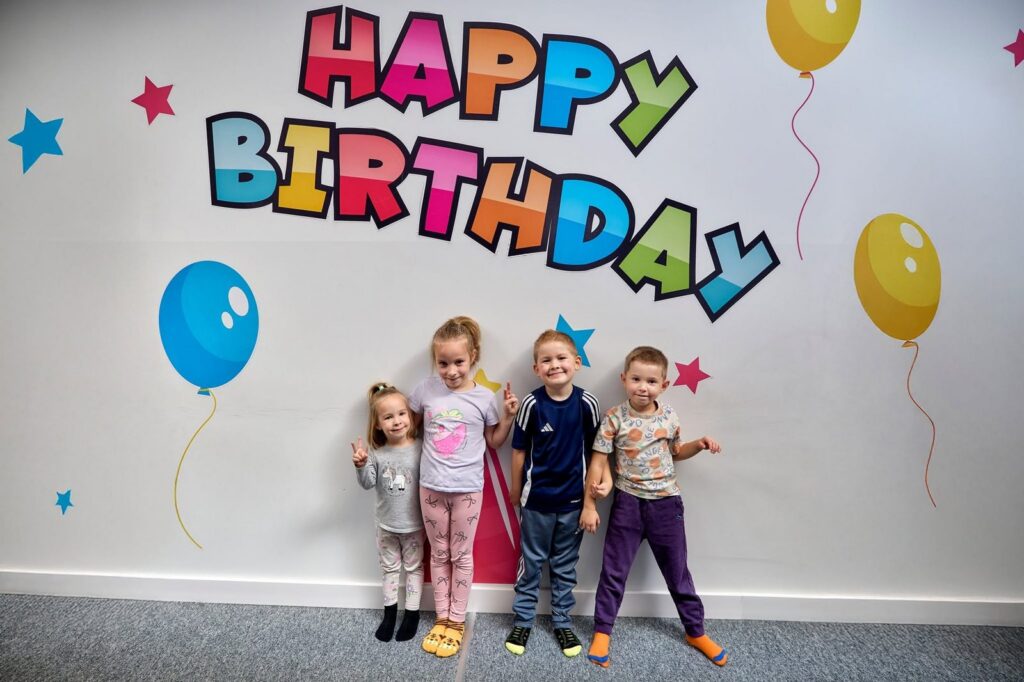 Dzieci pod napisem Happy Birthday w salce urodzinowej Parku Fantazja