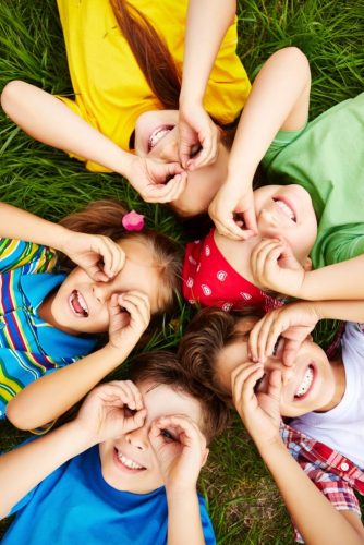 Group of cute children lying on grass